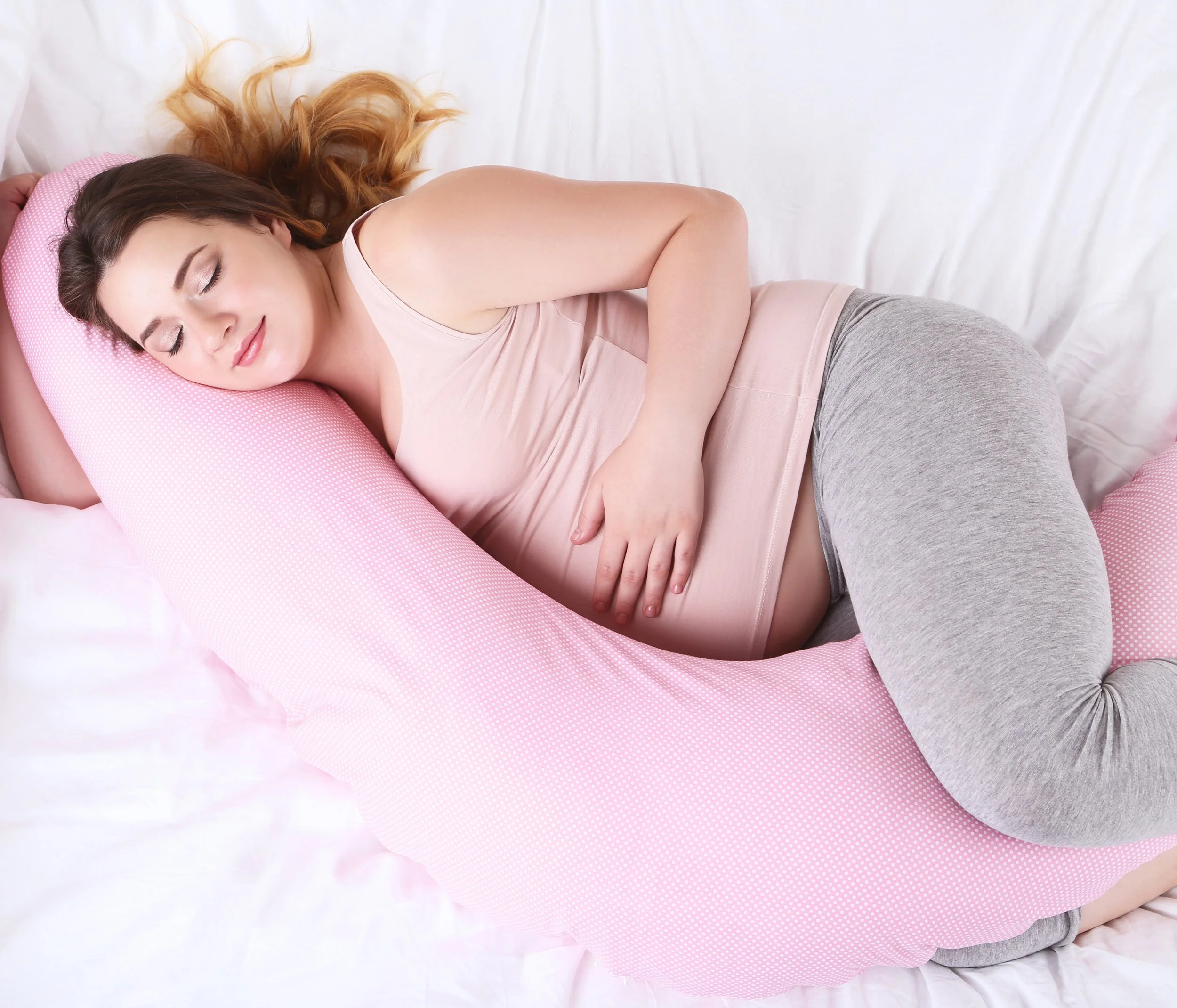 Pregnant woman sleeping with pregnancy pillow
